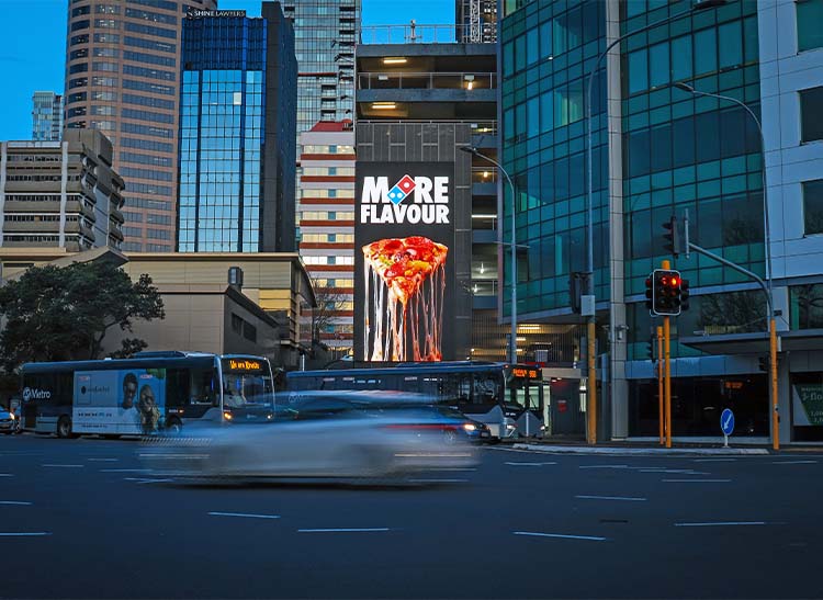 A MediaWorks digital billboard at City Gateway, Auckland, lit at night.